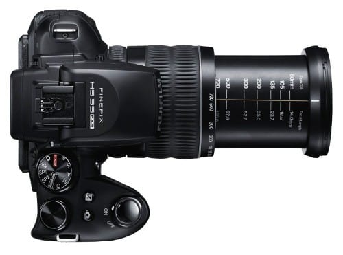 Widziany z góry czarny aparat cyfrowy FujiFilm FinePix z wysuniętym długim obiektywem.