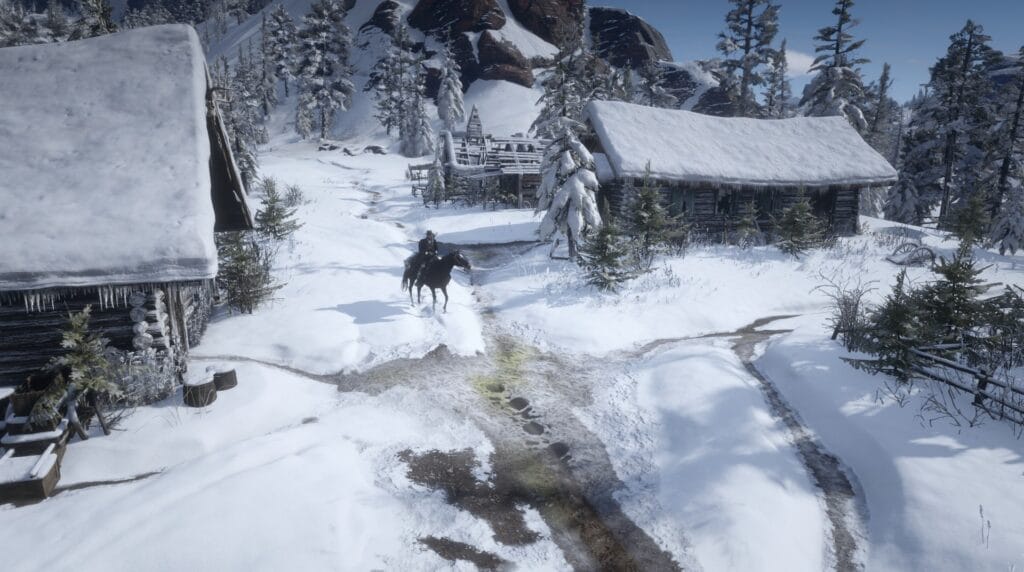 Zasypana śniegiem osada w górach. Dwie drewniane chaty, a za nimi rozpadające się resztki trzeciej. Pośrodku ubrany na czarno jeździec na czarnym koniu.