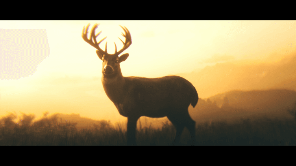 Kadr z wizji Arthura w złocistej sepii: w promieniach światła na łące stoi jeleń z wielkim porożem i głową zwróconą w stronę patrzącego.