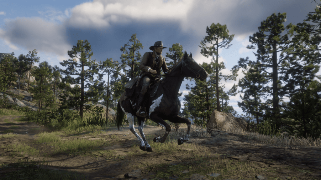 Arthur Morgan cwałuje na brązowo-białym koniu przez rzadki górski las sosnowy.