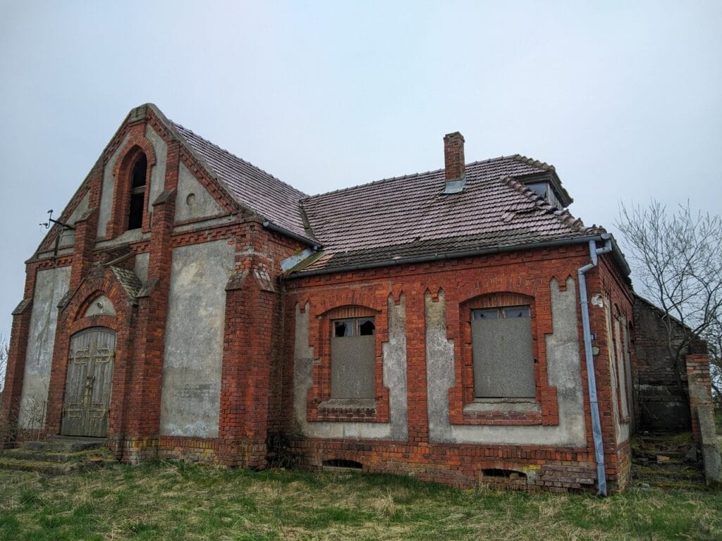 Ten sam budynek widziany z prawego rogu. Widoczne schody do pastorówki z osłaniającym murkiem.