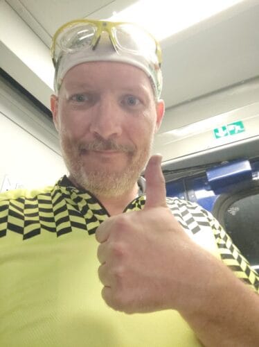 Selfie w żółtej koszulce rowerowej i białej chuście na głowie. Pokazuję do kamery kciuk w górę.